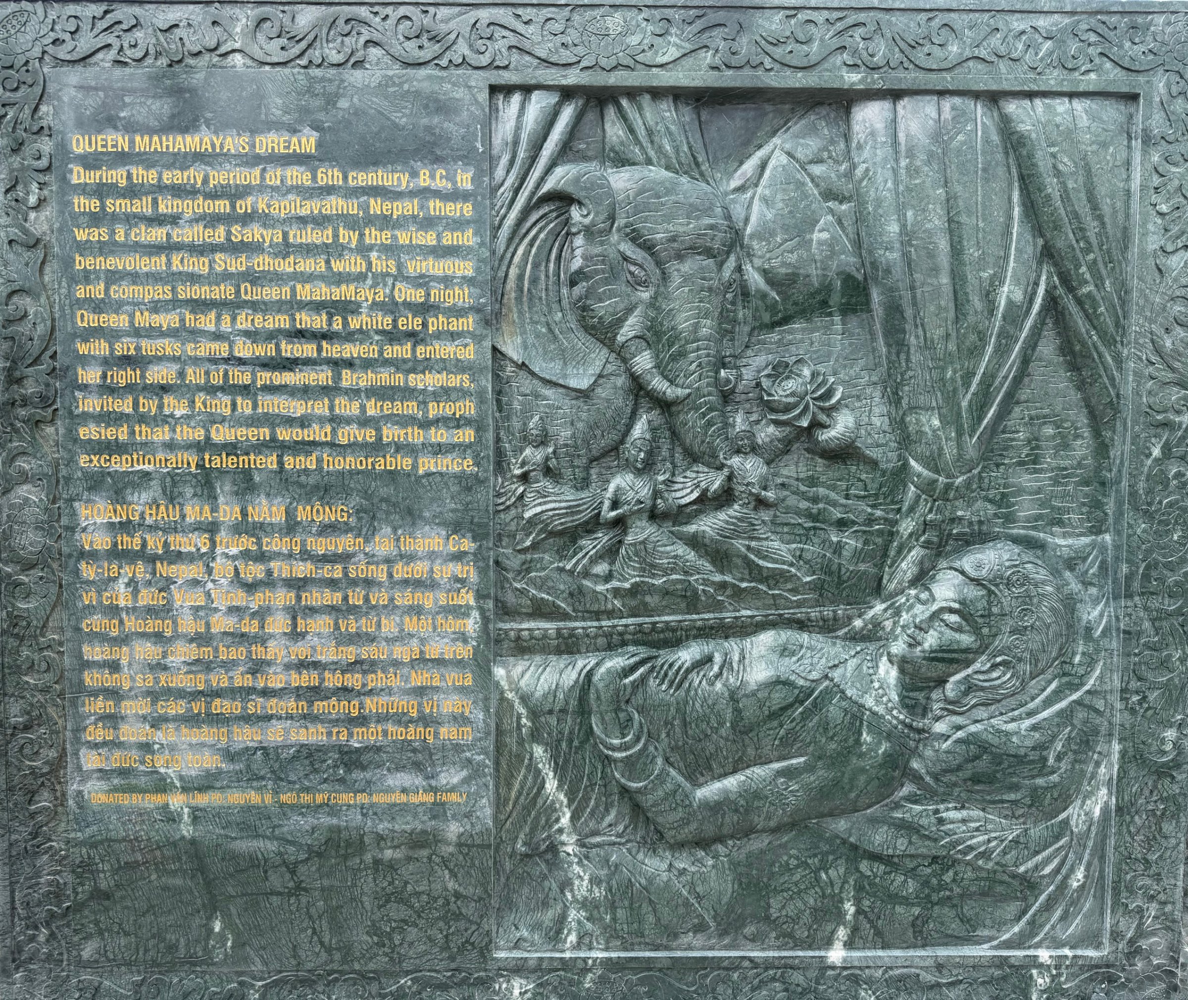 Carved stone panel 1 of the life of the Buddha: relief beside its English and Vietnamese text