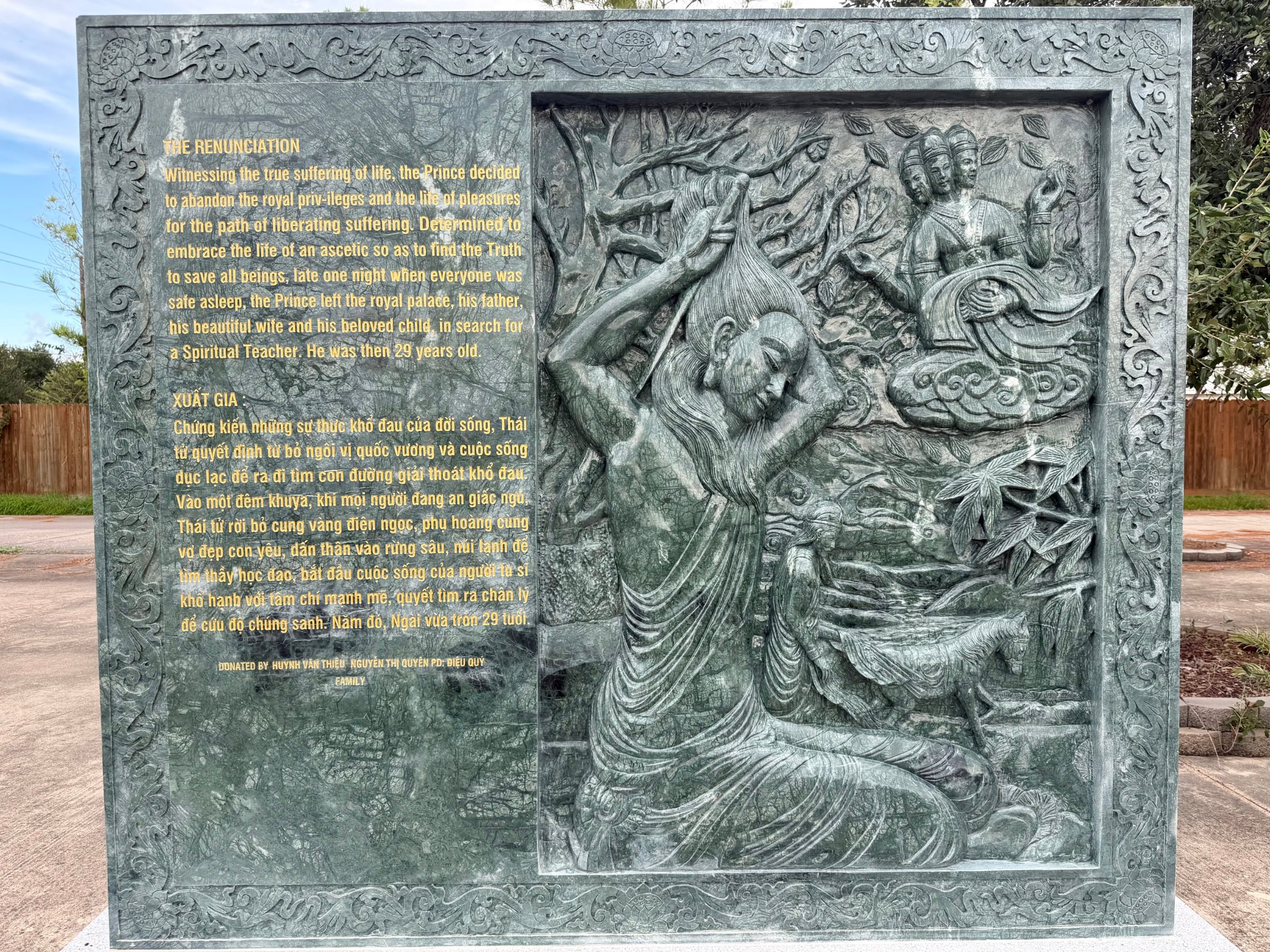 Carved stone panel 5 of the life of the Buddha: relief beside its English and Vietnamese text